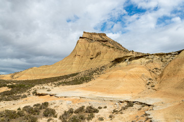 Steep mountain with a shrubby foothill in the badlands Bardenas Reales