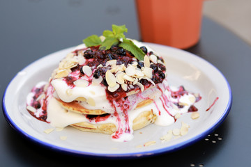 Classic american pancakes with fresh berry and coffee on the table. Pancakes with fruit and berry sauce. Summer homemade breakfast with raspberry tea. Dessert with a pink drink