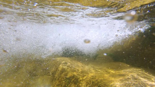 Water flowing in a rocky river, moving camera over and under water surface, Spain, La Muga, Catalonia
