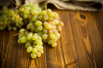 bunch of green grapes on a dark wooden table