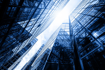 Skyscraper glass facades on a bright sunny day with sunbeams in the blue sky