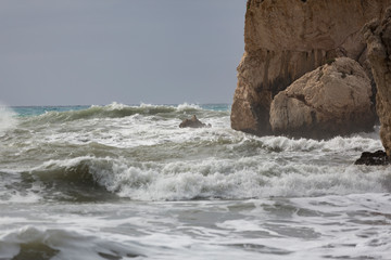 Fototapeta na wymiar Wave splashes against Aphrodite's Rock, Cyprus.