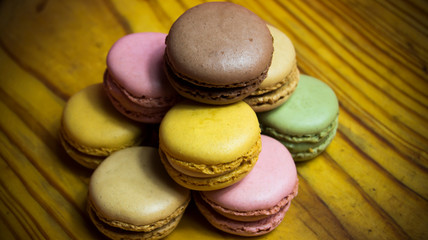 Colored macarons isolated on wooden dish, typical French dish