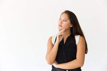 Thoughtful serious female customer touching chin and looking at copy space away. Young Latin woman...