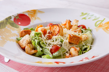 Caesar salad with seafood, the plate says pasta.