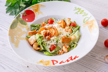 Caesar salad with seafood, the plate says pasta.