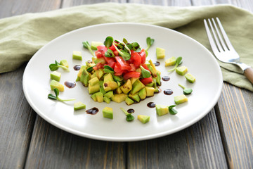Plate with healthy salad on table