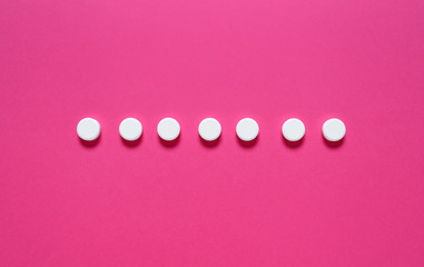 Row of pills on color background