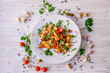fried potatoes with mushrooms meat onions on a plate wooden white background