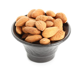 Bowl with tasty almonds on white background
