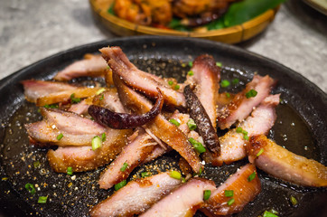 Asian food - slice grilled pork with spicy barbecue sauce serve on iron pan