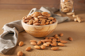 Bowl with tasty almonds on table