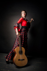 Carmen beautiful woman in red dress, with guitar on dark background