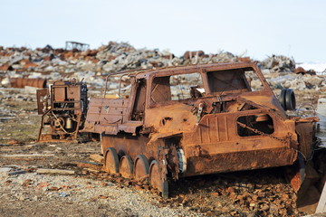 Fototapeta na wymiar Amphibious vehicle and piles of scrap metal waste in the Arctic