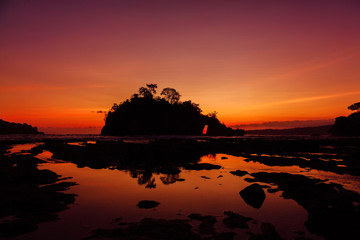 Rocks island in ocean with bright  warm sunset at Nusa Penida