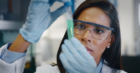 Portrait of dark skin female scientist is analyzing a liquid to extract the DNA and molecules in...