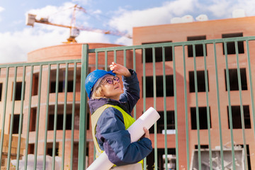 A woman Builder at a construction site inspects a house made of brick