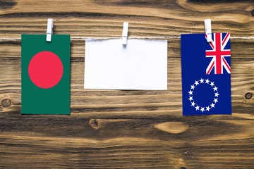 Hanging flags of Bangladesh and Cook Islands attached to rope with clothes pins with copy space on...