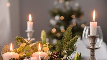 fragments of Christmas decor, cones, candles on the background of a decorated Christmas tree