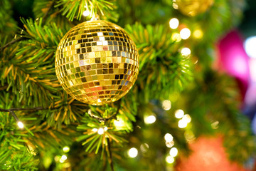 Closeup christmas tree and golden disco ball hanging of Christmas lights and New year