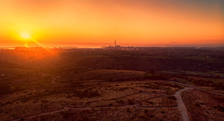Sunset in its golden hour on the Lazio hills,sun rays over the sea with Civitavecchia harbor...
