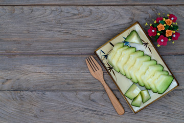 melon sliced on dish with wooden forkon wooden table