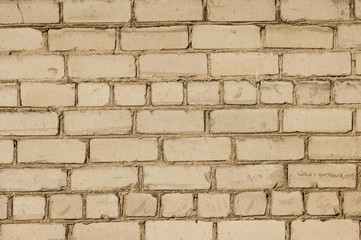 Texture of a brick wall coated with beige paint