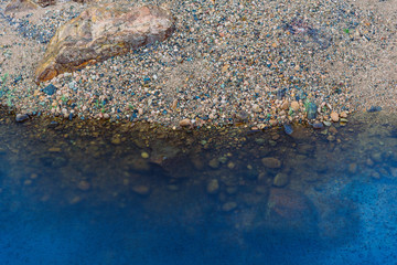 Seeufer mit unten Steinen