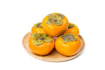 Persimmon on wood plate isolated on white background