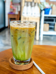 Mixed iced green tea and coffee beverage in glass in coffee shop