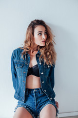 Fototapeta premium Portrait of a fashionable beautiful woman in denim shorts and lingerie