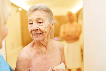 Alte Frau freut sich auf die Wellness Sauna
