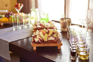 Сatering table with food and glass stemware at restaurant before party 