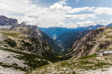 Fototapeta premium Dolomites, Italy - July, 2019: Drei Zinnen or Tre Cime di Lavaredo with beautiful flowering meadow, Sextener Dolomiten or Dolomiti di Sesto, South Tirol, Dolomiten mountains view, Italian Alps