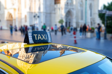 Taxi sign close-up. Tourist and city's attraction in background.