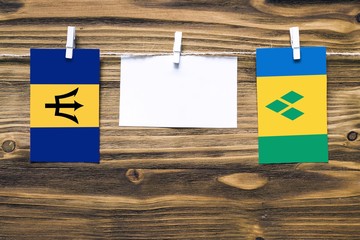 Hanging flags of Barbados and Saint Vincent And The Grenadines attached to rope with clothes pins...