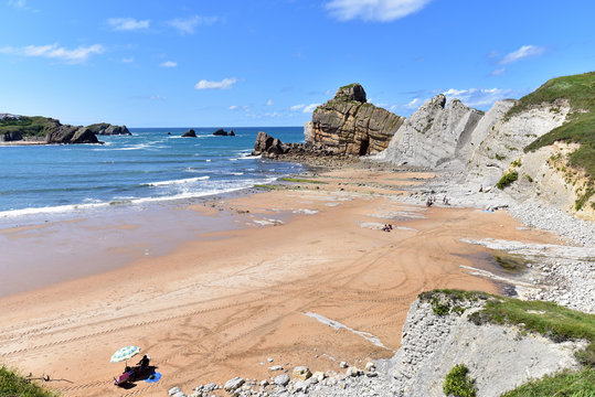 People on the beach of Playa Del Portio on a sunny day in santander, Cantabria, Spain