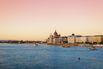 Fototapeta premium Budapest panorama with Parliament building, Danube and tourist boats. Sunset.