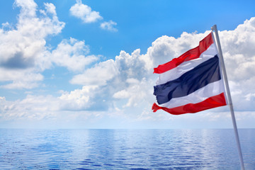 Fototapeta premium The Kingdom of Thailand flag, sea, sky, clouds beautiful seascape background, flag on pole waving on wind, state independence symbol, Thai national sign, red, white, blue color stripes banner close up