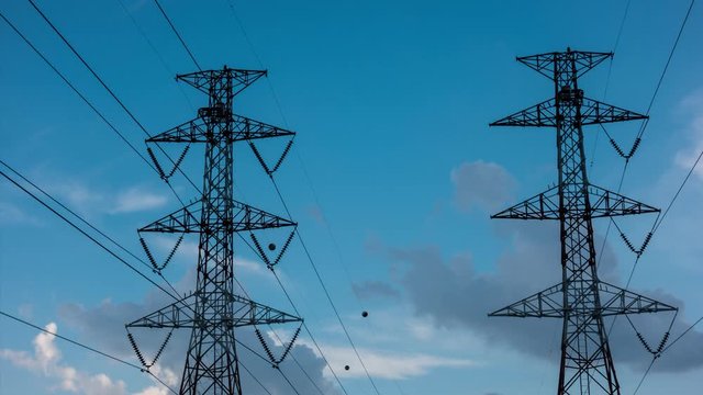 4K Time Lapse of high voltage post. High-voltage tower sky background. electric pole with blue sky and clouds.