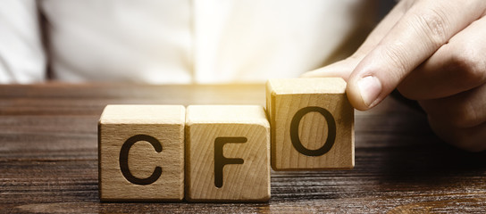 A man makes the word acronym abbreviation CFO. Chief Financial Officer. Financial management in business and company. Risk. Development and growth. Appointment to a new post, promotion. - obrazy, fototapety, plakaty