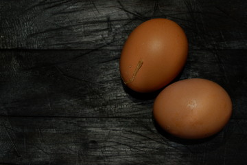 Two eggs on the wooden background.
