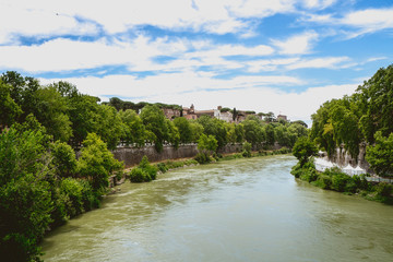 the Tiber river in the middle of nature green trees and plant