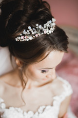 Gorgeous bride in robe posing and preparing for the wedding ceremony face in a room