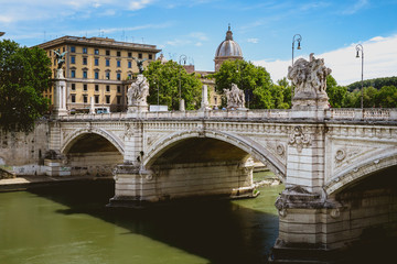 Tiber river streams, Ponte Vittorio Emanuele II bridge, flying seagulls and Rome cityscape view with famous St. Peter dome on the background