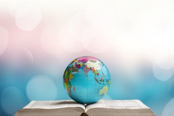 Heavy open book and globe on abstract background