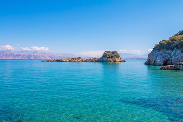 Rocky beach landscape on summer day, Beautiful turquoise color sea water. Corfu, Greece.