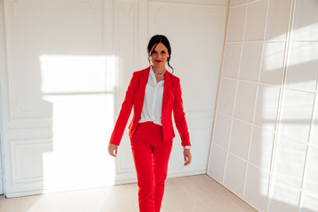 Portrait of a beautiful business woman in a red business suit in the office