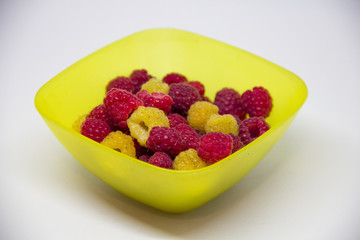 yellow and red raspberries in a yellow vest on a white background