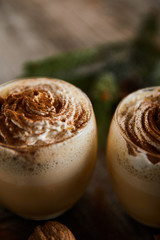 close up view of delicious eggnog cocktail with whipped cream and cinnamon on wooden table